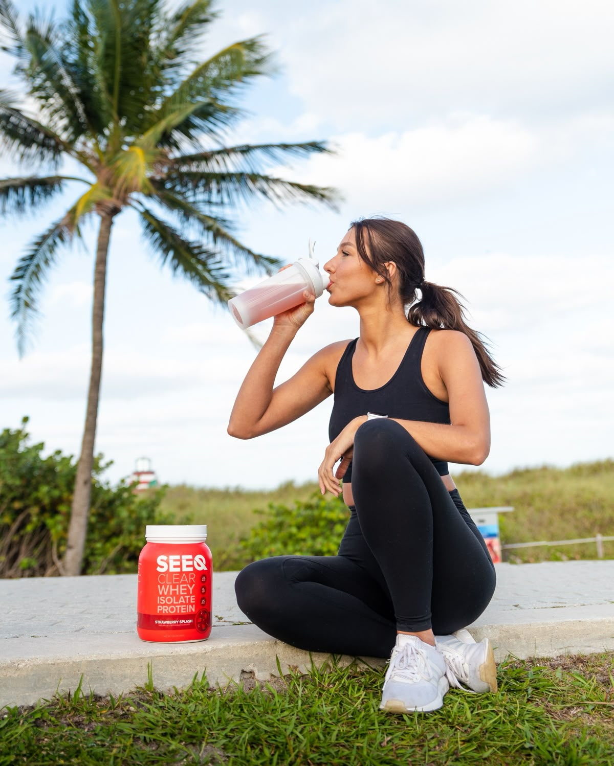 Modelo bebendo shake de proteína ao ar livre